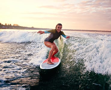 woman riding a wave on a surfboard