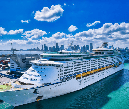 cruise ship in port under bright blue sky dotted with white clouds