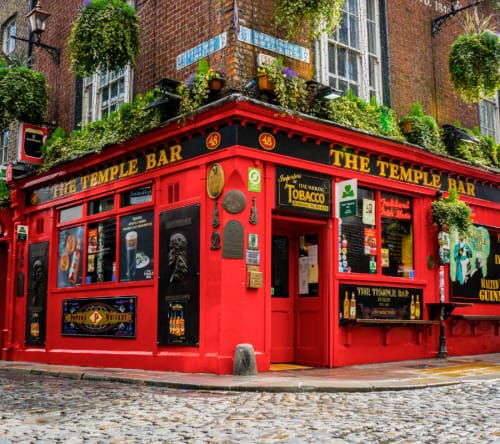 Red corner tavern on a cobble street in Dublin