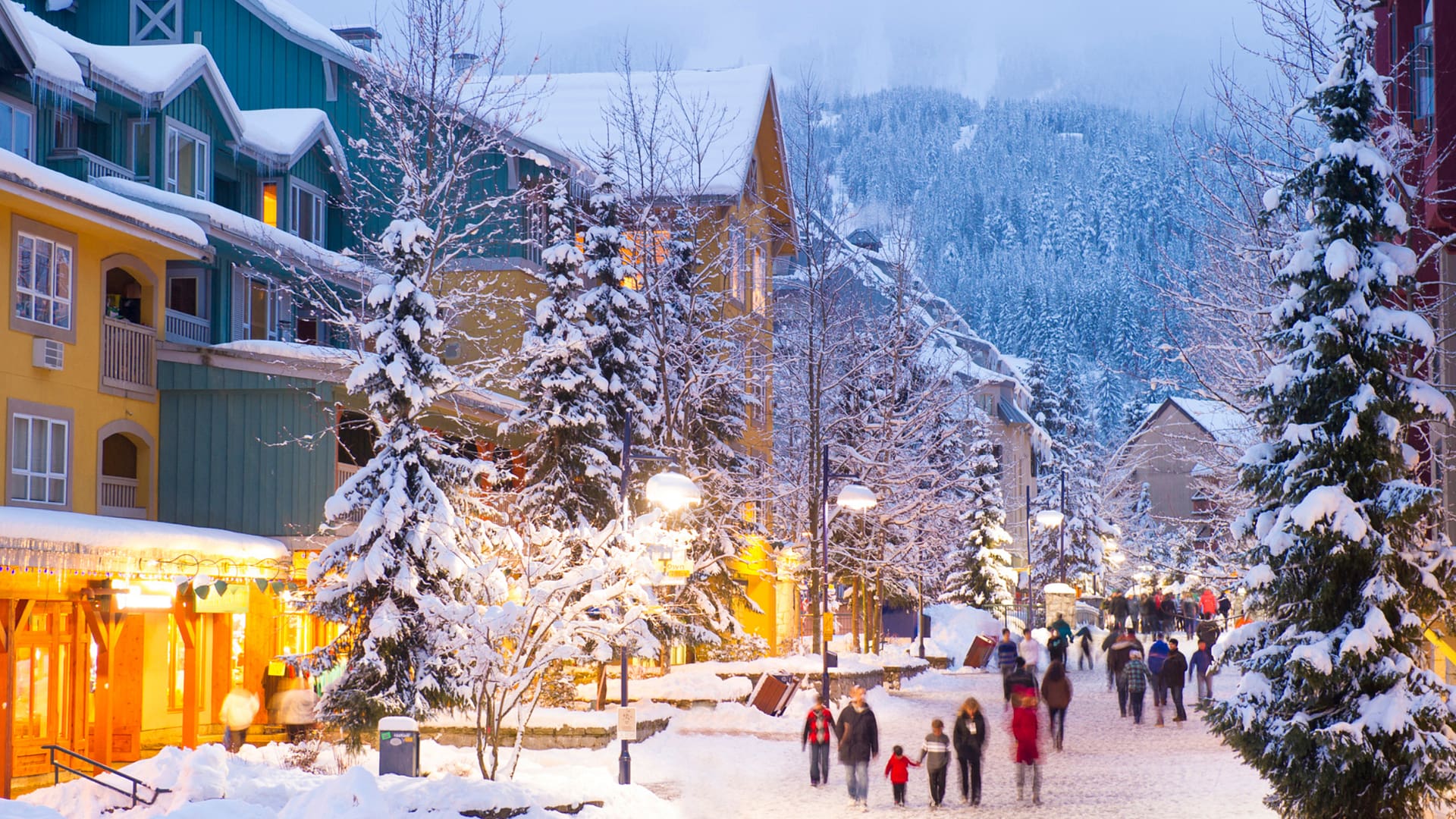 Whistler's world class pedestrian village filled with shops, hotels and restaurants blanketed with fresh snow at dusk