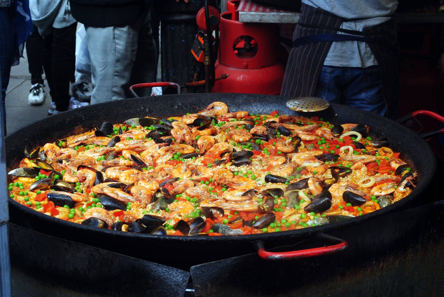 Explore Madrid with food delicious paella with mollusks in big frying pan