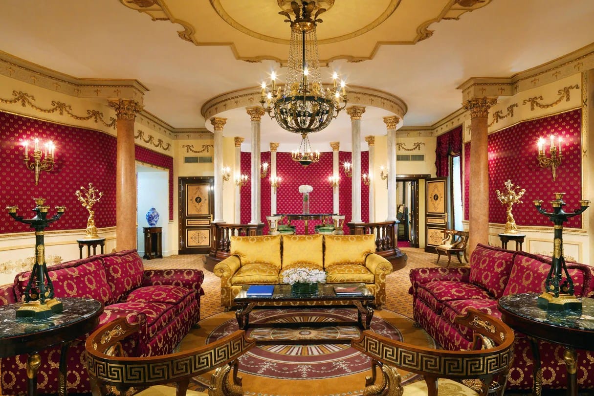 Exploring Rome with a lavish red, gold, and cream sitting area in suite